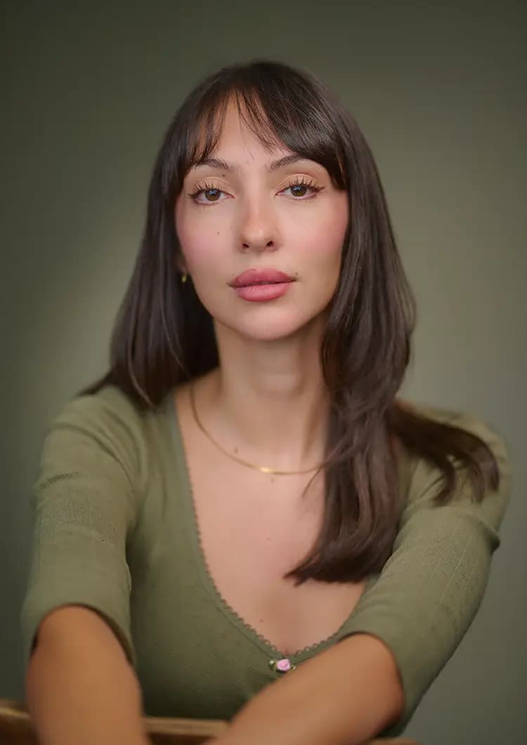 Seated actor headshot of Rosie Lou photographed against a green canvas backdrop in a London studio