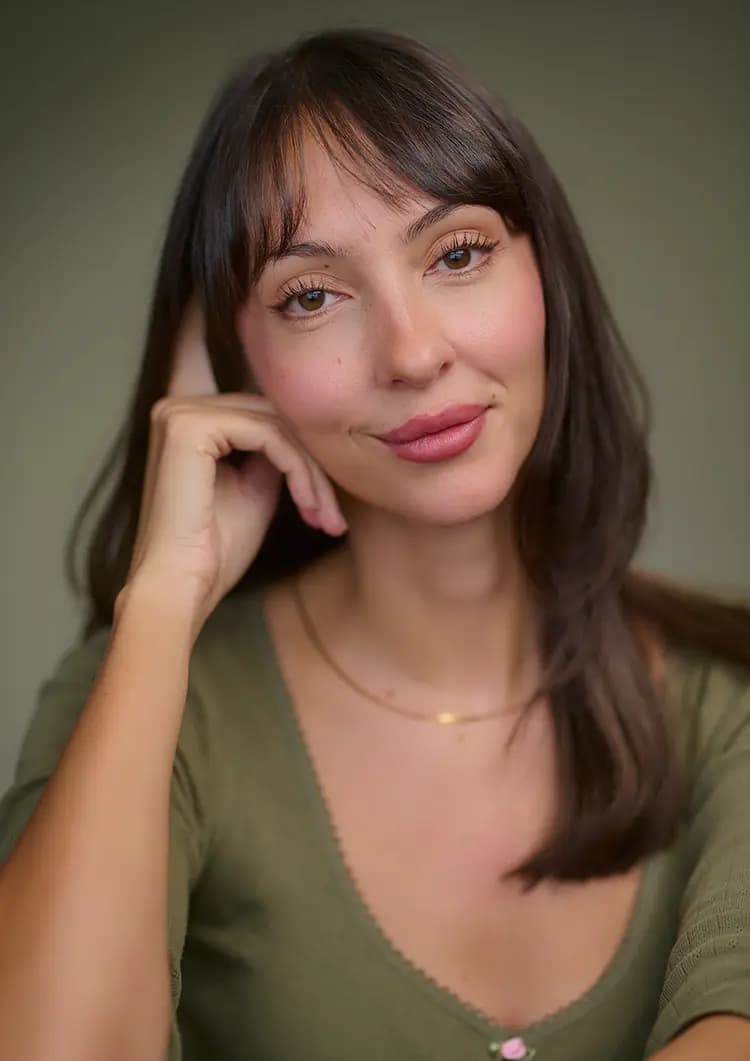 Natural seated portrait of actress Rosie Lou with green canvas background during actor headshot session
