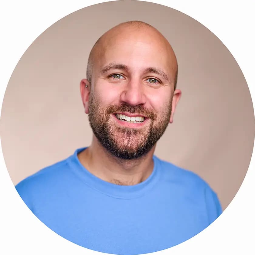 Professional LinkedIn headshot of a marketing executive smiling against a soft pink studio background