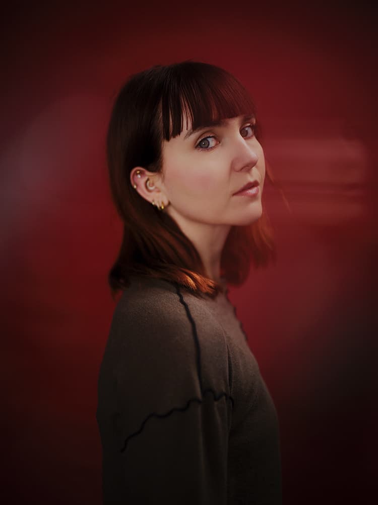 Portrait of actress Tess Hermann in Herne Hill Studio with deep red backdrop
